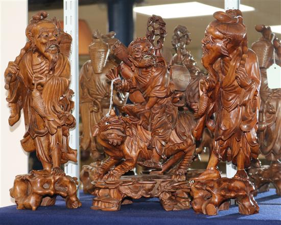 A pair of Chinese carved hardwood figures of fishermen and another figure of a demon riding a lion dog (3) H.38cm